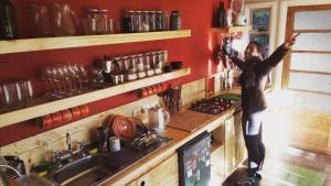 Eine Frau, die in einer Küche steht und eine Kamera hochhält. in der Unterkunft Treehouse Patagonia in Puerto Natales