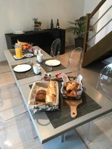 a table with bread and pastries on it at Chambres d'hotes Karine SMEJ in Châtillon-sur-Marne