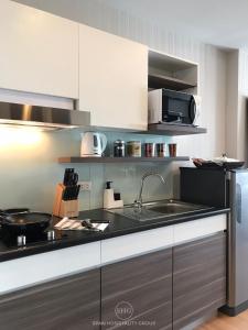 a kitchen with a sink and a microwave at Stay in Style, Stay On The Cloud RS504 in Chiang Mai