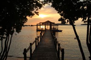 a dock with a gazebo on the water at sunset at River Hotel in Hà Tiên