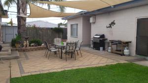 a patio with a table and chairs and a grill at Kadina Village Motel in Kadina