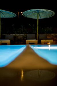 ファナリにあるAnemoessa Luxury Villasの夜間のスイミングプール(傘付)