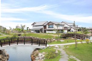 una casa con un ponte sopra un laghetto di Dancewoods Hotel a Wujie