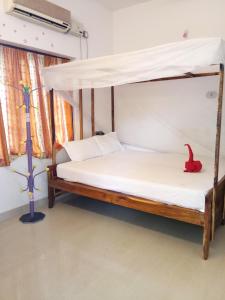 a bedroom with a canopy bed with a red bird on it at Gone Coastal Homestay in Varkala