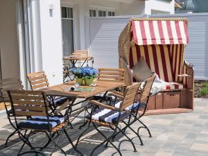 a wooden table and chairs on a patio at Reetperle Lobbe - Ferienhaus mit Sauna (F 650) in Lobbe