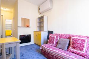 a living room with a pink couch and a table at Résidence Meublée Services in Marseille