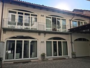 ein großes Haus mit großen Fenstern und einem Balkon in der Unterkunft Alla Corte dei Bertoli SPA in Canale