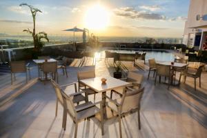 a rooftop patio with tables and chairs on a building at Hotel Sfax Palace by Plaza Hotels & Resorts in Sfax
