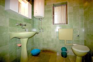 uma casa de banho com um lavatório e um WC em Apartments Begic em Malinska
