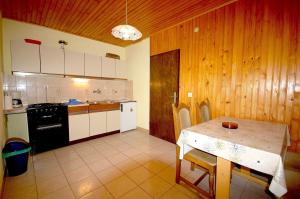 a kitchen with a table and a kitchen with wooden walls at Apartments Begic by El-Pi Tours in Malinska