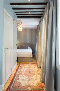 a bedroom with a bed and a window and a rug at Ateliers de Montmartre ADM in Paris