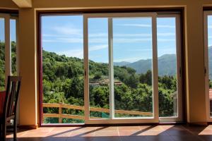 a room with a large window with a view of the mountains at Encostas da Torre in Terras de Bouro