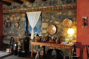 a stone wall with a table and a window at Petrogonima in Palaios Agios Athanasios