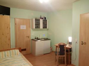 a room with a bed and a kitchen with a sink at Pension "Am Tor zum Mainbogen" in Grettstadt