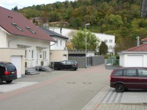two cars parked in a parking lot next to houses at Ferienwohnung Keil in Lahr