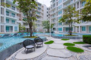 a courtyard with chairs and a pool in a building at Summer HuaHin Condominium in Hua Hin
