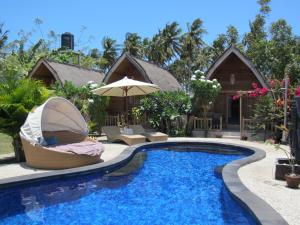 a villa with a swimming pool and a resort at Djamezz Lumbung in Gili Air