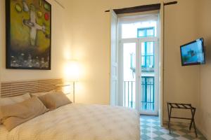 una camera con letto, TV e finestra di Haripergo Apartments a Salerno
