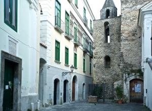 un vicolo tra due edifici con una torre di Haripergo Apartments a Salerno