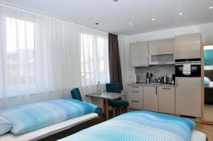 a bedroom with a bed and a kitchen with a table at Apartments am Freizeitpark in Kriftel