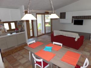 a living room with a table and a red couch at Fattoria di Anja e Marco in Costa Rei