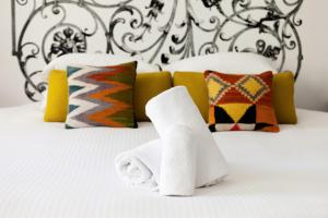 a white towel laying on top of a white bed at Une Chambre Chez Dupont in Bordeaux