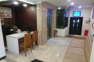Habitación con escritorio, mesa y sillas. en SAAS Residency, en Kozhikode