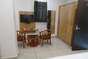 a room with two chairs and a table and a television at SAAS Residency in Kozhikode