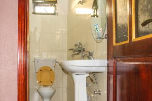 a bathroom with a toilet and a sink at Hotel Gorilla's Nest Entebbe in Kitende