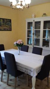 a dining room table with a vase of flowers on it at Gite de la ferme du couvent in Boran-sur-Oise