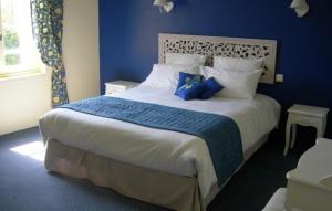 a bedroom with a large bed with blue walls at Gite de la ferme du couvent in Boran-sur-Oise