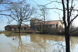 a house sitting next to a body of water at Agriturismo Ca' Preda in San Giorgio Piacentino