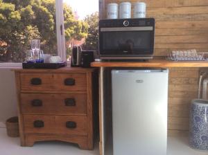 a microwave sitting on top of a counter with a refrigerator at Kommetjie Heaven in Kommetjie
