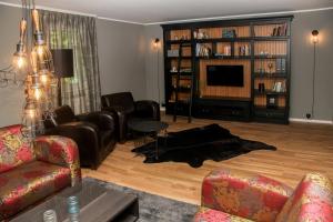 a living room with couches and a tv at Schlossberghotel Greiz in Greiz