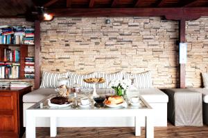 a white table with food on it in front of a brick wall at Poseidon Villas in Skiathos