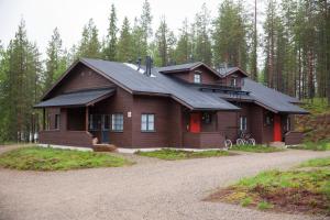 a large wooden house in the middle of a forest at Holiday Club Salla Apartments in Salla