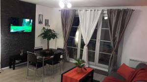 a living room with a couch and a table and a tv at DISNEYLAND PARIS/VAL 2 APART' in Montévrain +7 photos