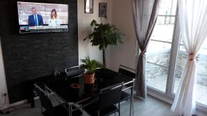 a dining room with a table and a tv on a wall at DISNEYLAND PARIS/VAL 2 APART' in Montévrain