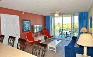 a living room with a blue couch and red chairs at Sunrise Suites Antigua Suite #312 in Key West