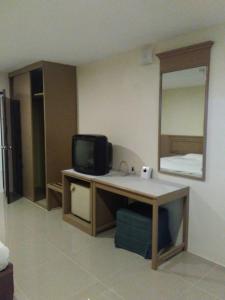 Ein Zimmer mit einem Schreibtisch, einem Fernseher und einem Spiegel in der Unterkunft Tongpoon Hotel in Bangkok + 18 Fotos