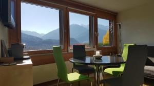 ein Esszimmer mit einem Tisch und Stühlen vor einem Fenster in der Unterkunft Ferienwohnung mit Sicht auf die Berge (Nähe Flims/Laax) in Trin