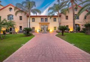 a large building with palm trees and a brick walkway at DWO Valencia in Valencia