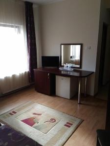 Habitación con escritorio, espejo y alfombra. en Vila Montana, en Constanţa