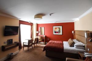 a hotel room with a bed and a television at Seamill Hydro Hotel & Resort in Seamill