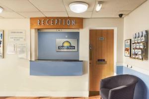 a reception room with a sign on the wall and a chair at Days Inn Watford Gap in Crick