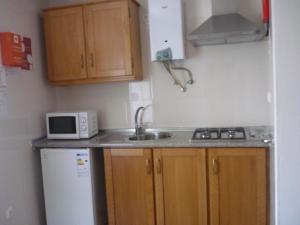 a small kitchen with a sink and a microwave at Casa do Arco da Praça in Elvas