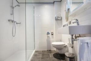 a bathroom with a shower and a toilet and a sink at Hotel Die Port van Cleve in Amsterdam