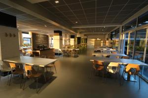 a row of tables and chairs in a cafeteria at ETHIC ETAPES DIJON Accueil 24h24 et parking gratuit in Dijon