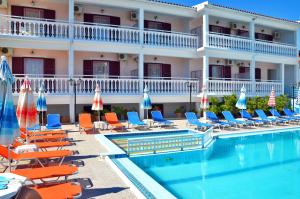 a hotel with a swimming pool with chairs and umbrellas at Bona Vista Studios in Laganas