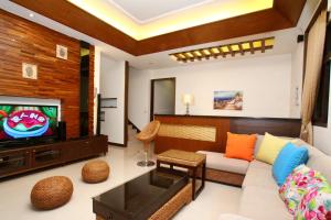 a living room with a couch and a tv at 愛樂耕民宿 Elegant Homestay in Yuanshan